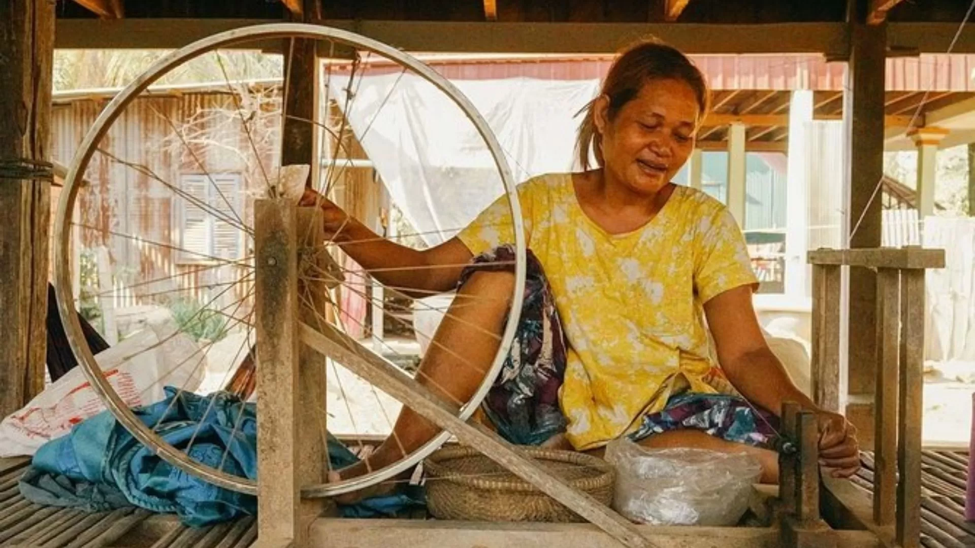 An elderly artisan carefully weaving traditional handmade silk fabric, keeping the ancient craft alive.