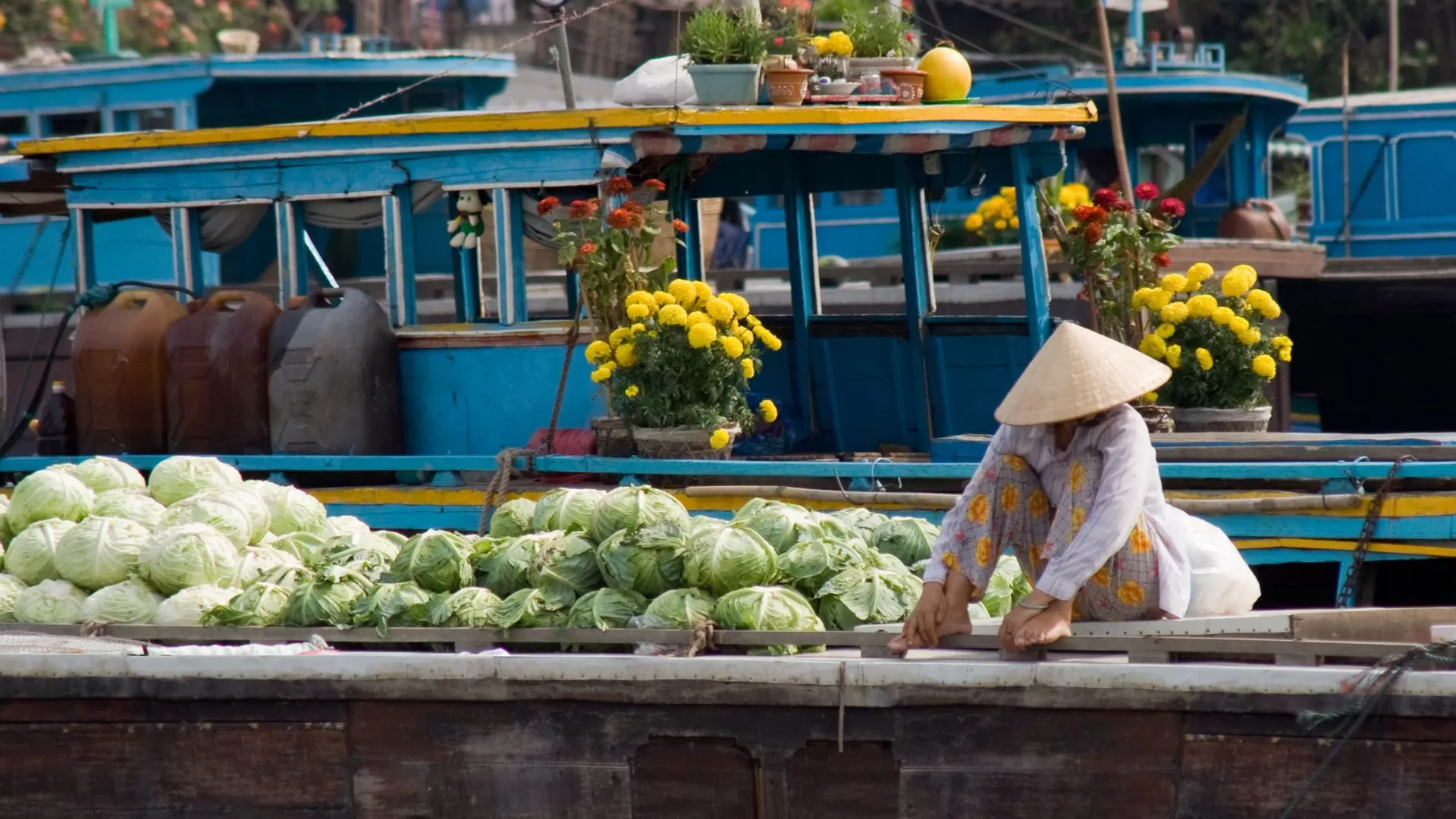 Un marchand est assis sur un radeau contenant de la nourriture