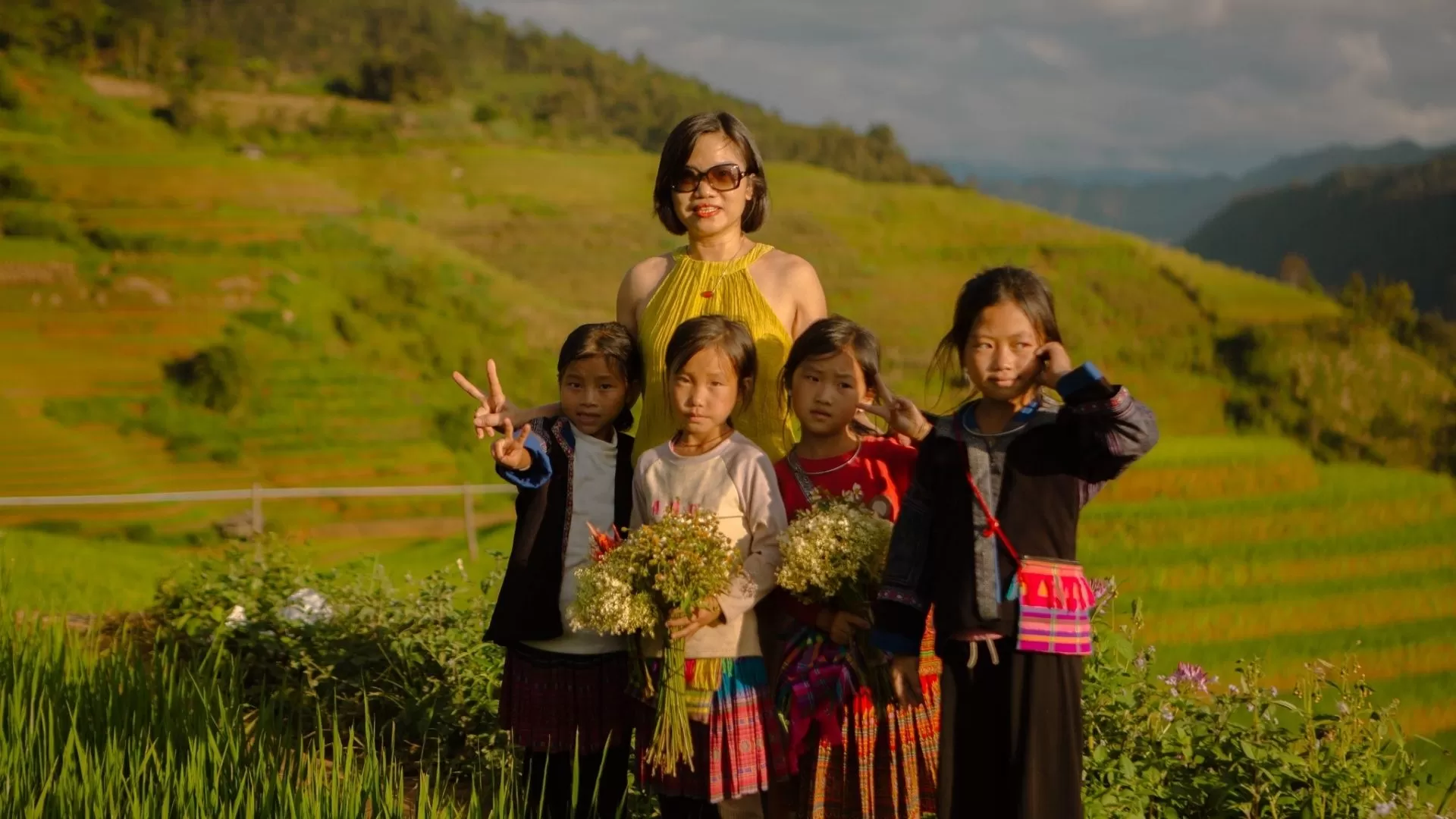 Travelers take a photo in the rice terraces of Mu Cang Chai with locals