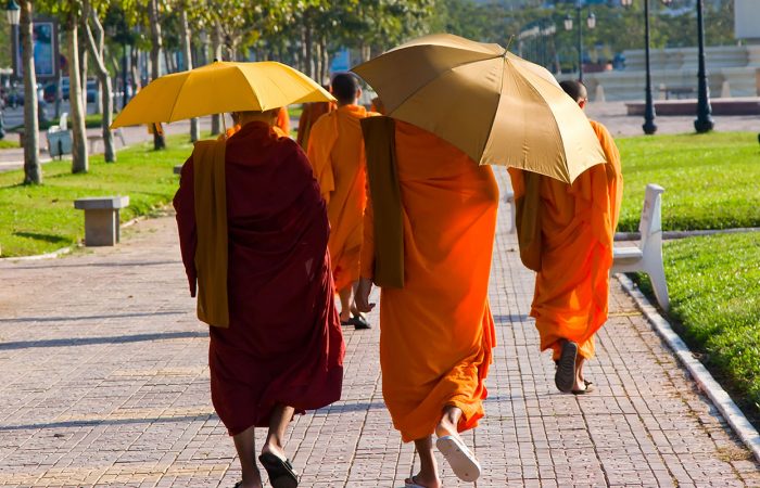 moines bouddhiste marchant en ville avec parapluies, Cambodge