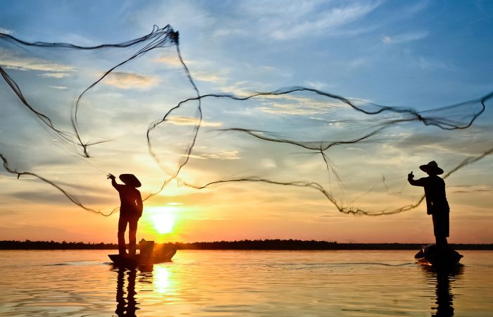 Pêcheurs lançant leurs filets au lever du soleil