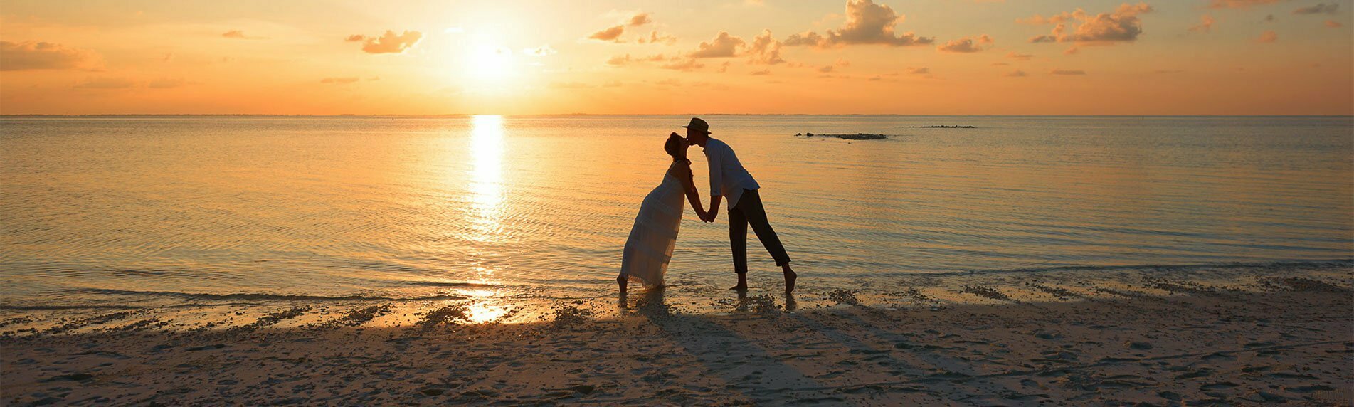 Couple s'embrassant sur la plage pendant le coucher de soleil