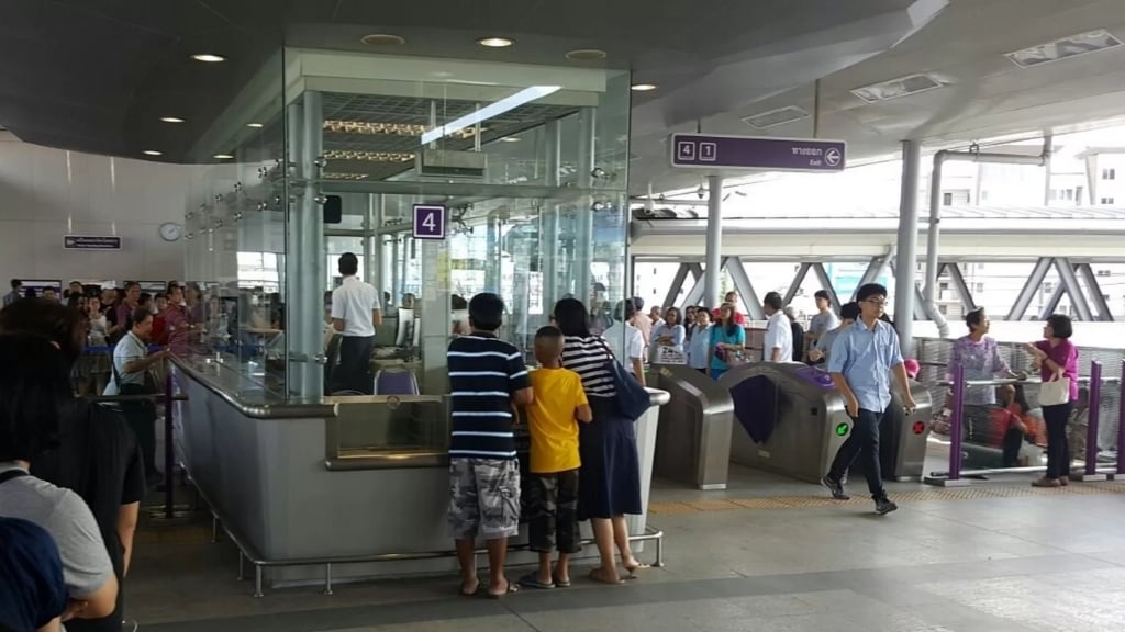 Les gens achètent les billets au guichet