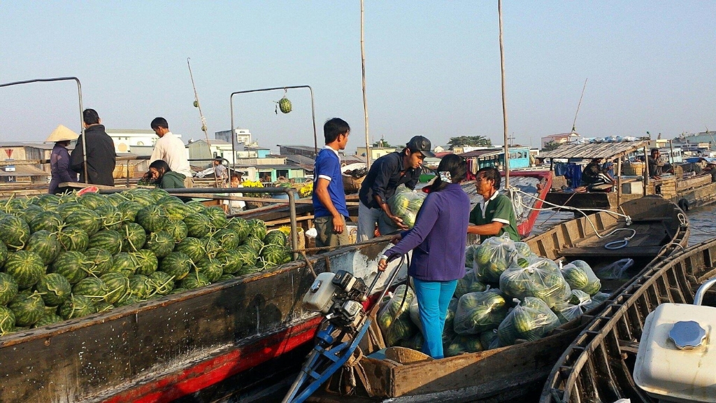Un marchand est assis sur un radeau contenant de la nourriture Marchand flottant et ses mets locaux