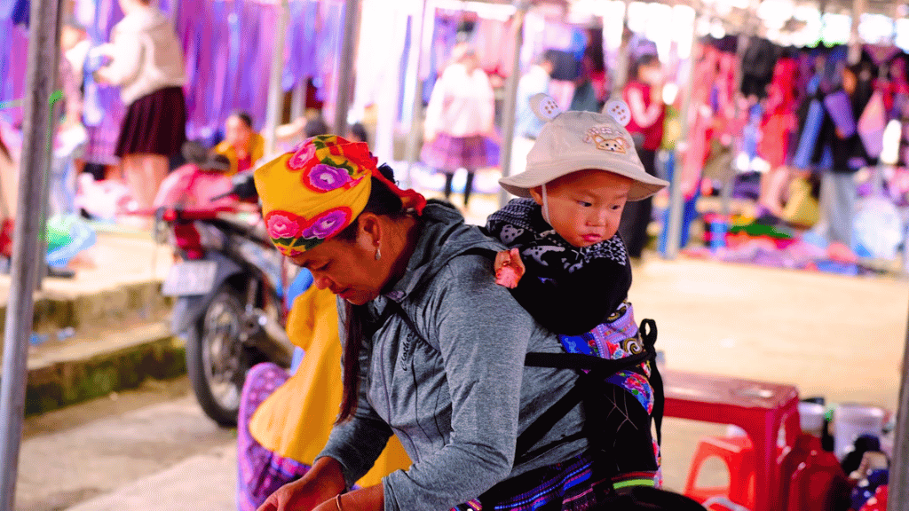 Les femmes Hmong portent souvent leur bébé sur le dos tout en poursuivant leurs activités quotidiennes