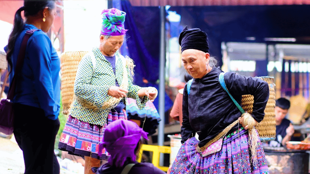 Entre conversations et vente, les femmes Hmong filent patiemment les fibres de chanvre, un geste familier qui accompagne leur quotidien